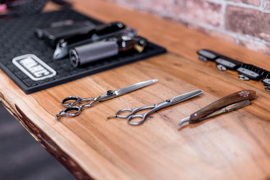 Barber shears, thinning scissors and a straight razor laid out on a wooden counter